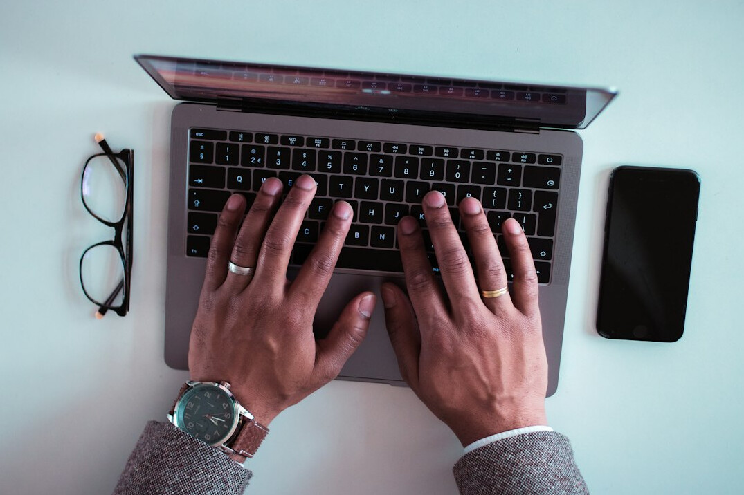 mystery writer typing on laptop