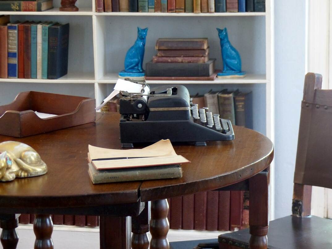 writer at desk with books